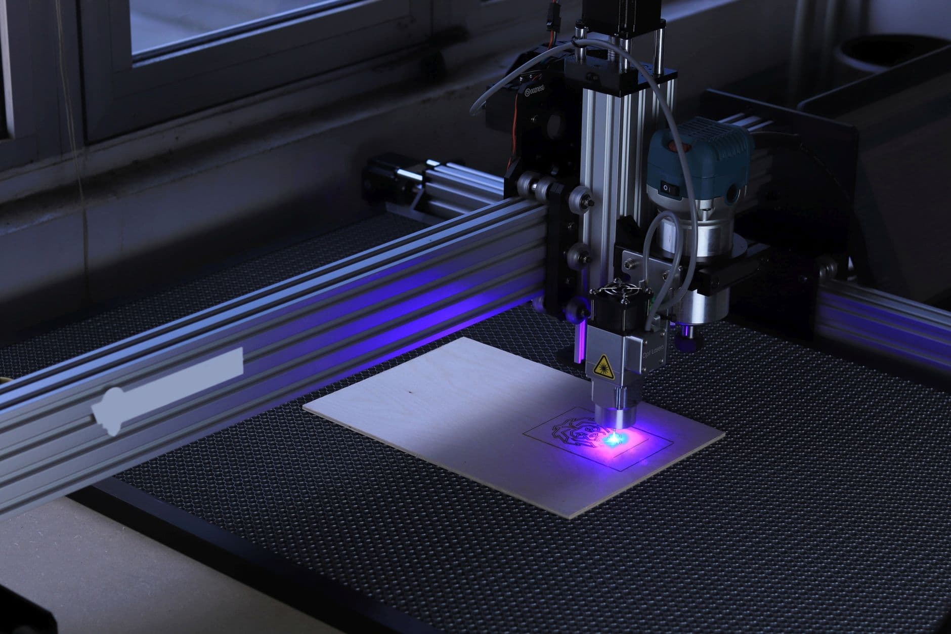 A laser cutter cutting a sheet of plywood